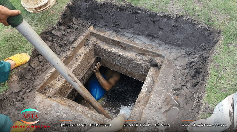 Thành và vách ngăn bể phốt đang được thi công với đường ống xuyên thành